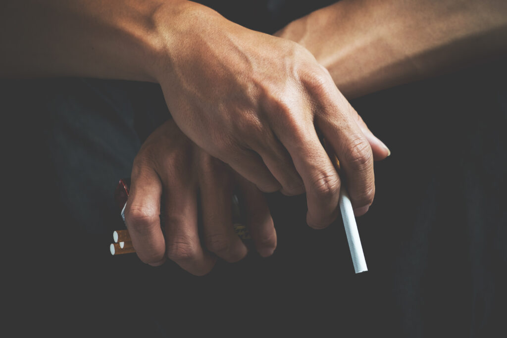 osoba w dłoniach trzyma papierosy