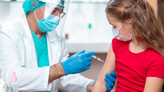 dziecko przyjmuje szczepienie przeciwko COVID