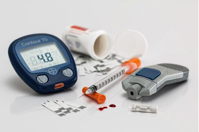 Obrazek przedstawia glukometr, insulinę oraz tabletki zażywane podczas leczenia cukrzycy